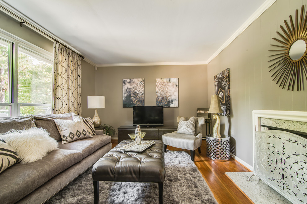 Immagine di un piccolo soggiorno chic con pareti grigie, pavimento in legno massello medio, camino classico e TV autoportante