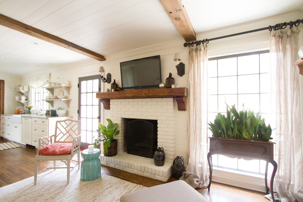 Family room - traditional open concept medium tone wood floor family room idea in Atlanta with beige walls, a standard fireplace, a brick fireplace and a wall-mounted tv