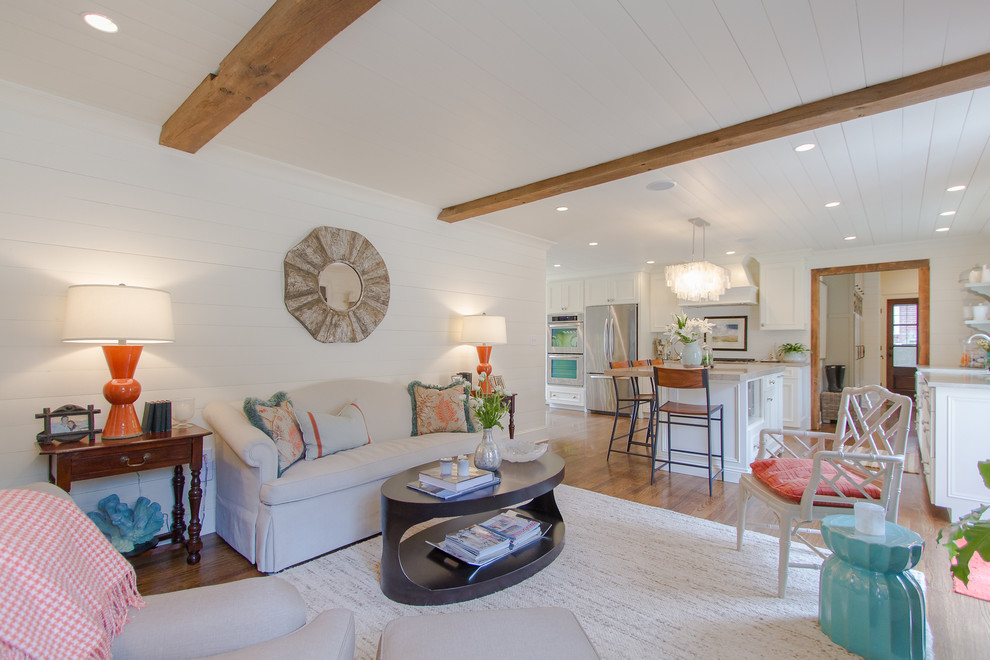 Diseño de sala de estar abierta tradicional con paredes blancas y suelo de madera en tonos medios