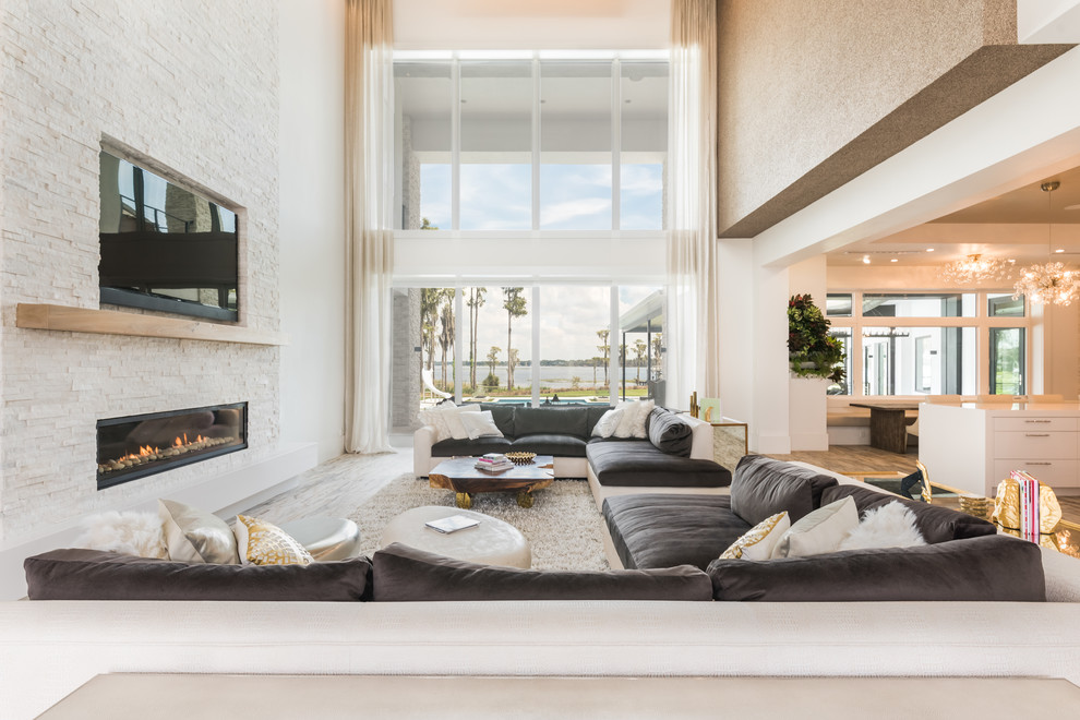 Идея дизайна: гостиная комната в современном стиле с белыми стенами, горизонтальным камином и телевизором на стене