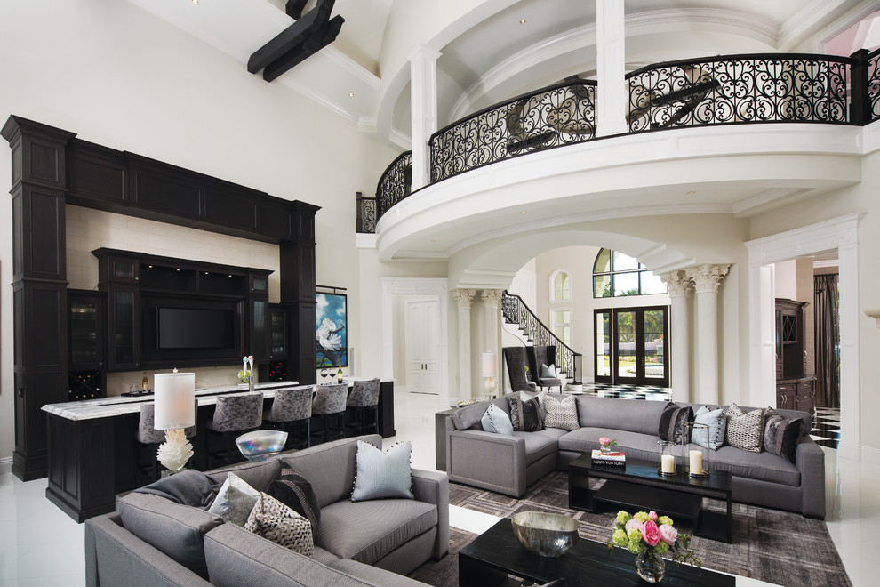 Offenes Klassisches Wohnzimmer mit Hausbar, beiger Wandfarbe, TV-Wand und weißem Boden in Miami