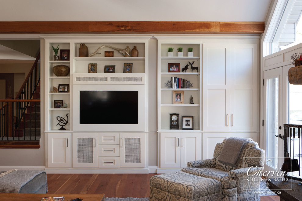 Ejemplo de sala de estar abierta escandinava de tamaño medio sin chimenea con paredes beige, suelo de madera clara y pared multimedia