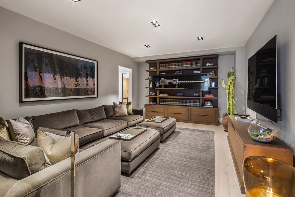 Medium sized contemporary enclosed games room in New York with light hardwood flooring, no fireplace, a wall mounted tv, grey walls and beige floors.