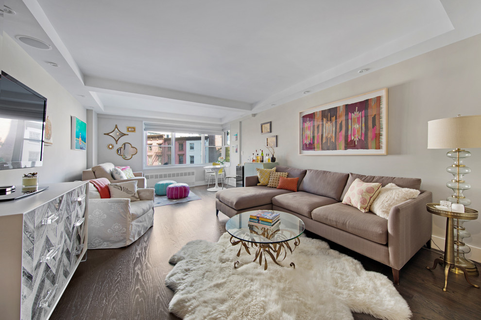 Ejemplo de sala de estar abierta ecléctica con paredes beige, suelo de madera oscura, televisor independiente y suelo marrón