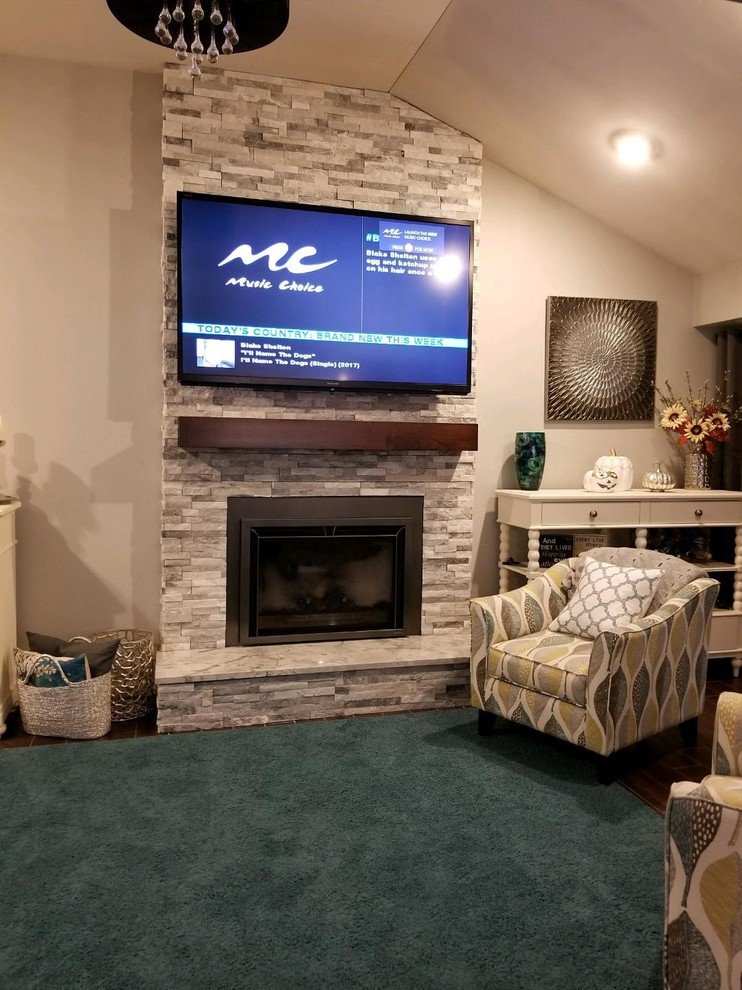 На фото: гостиная комната среднего размера в стиле кантри с бежевыми стенами, ковровым покрытием, стандартным камином, фасадом камина из камня, телевизором на стене и зеленым полом
