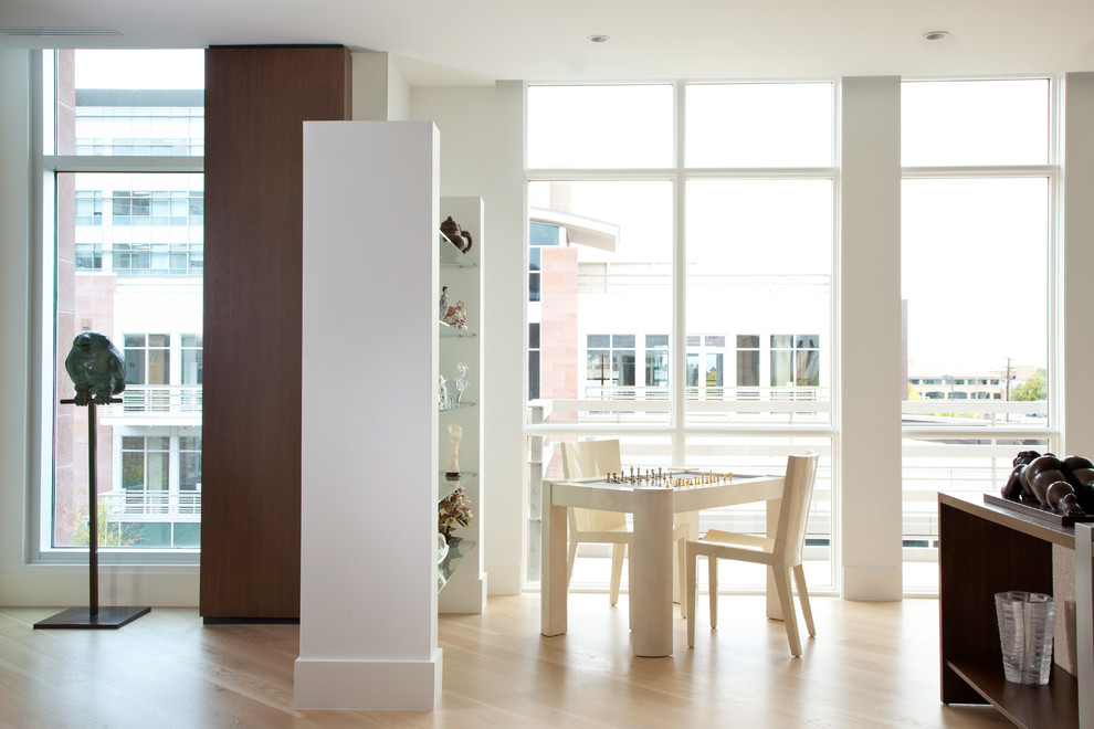 Ejemplo de sala de juegos en casa abierta contemporánea grande sin televisor con paredes blancas, chimenea de doble cara y suelo de madera en tonos medios