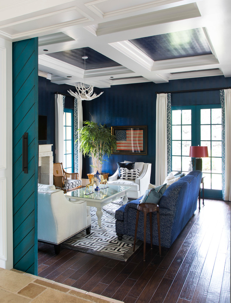 Esempio di un soggiorno bohémian chiuso con pareti blu, parquet scuro, camino classico, pavimento marrone, parete attrezzata e tappeto