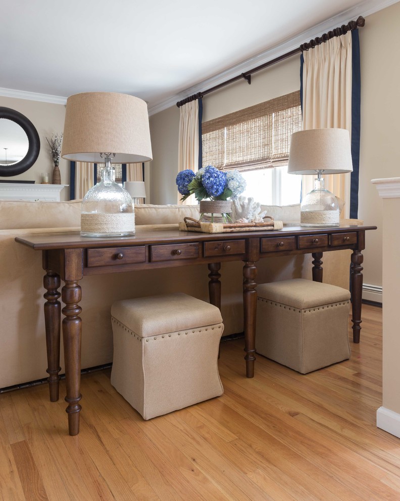 Modelo de sala de estar abierta marinera grande con suelo de madera en tonos medios, pared multimedia y paredes beige