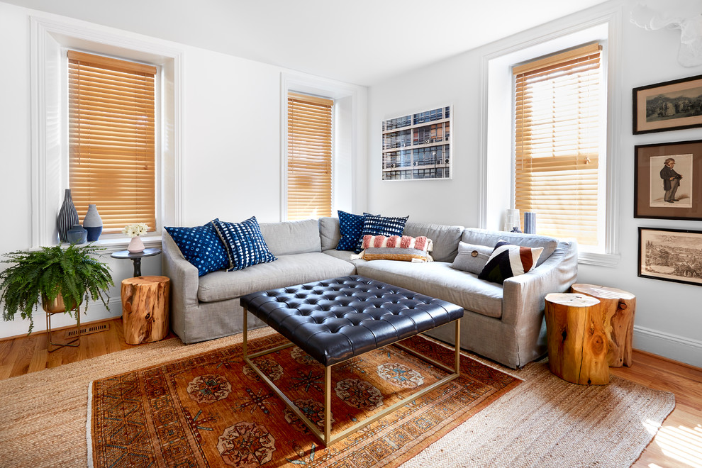 Foto di un soggiorno classico di medie dimensioni con pareti bianche, pavimento in legno massello medio, pavimento marrone e tappeto