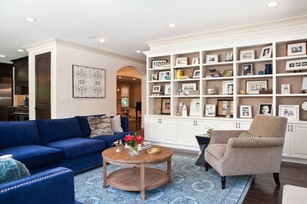 Modelo de sala de estar abierta tradicional renovada con paredes beige y suelo de madera oscura