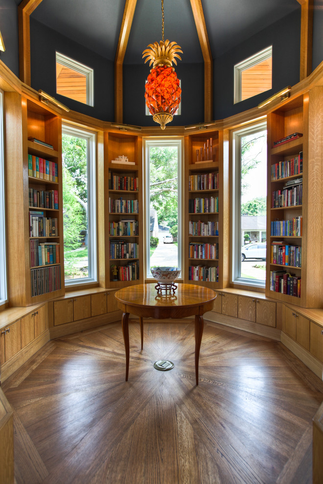 Imagen de sala de estar con biblioteca clásica con suelo de madera oscura