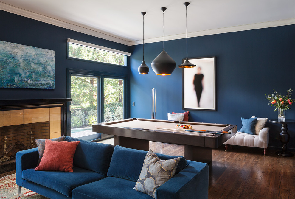 На фото: открытая гостиная комната в современном стиле с синими стенами, темным паркетным полом, стандартным камином и коричневым полом