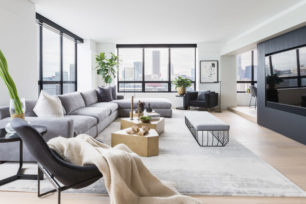 Trendy enclosed light wood floor and beige floor family room photo in Chicago with white walls, no fireplace and a wall-mounted tv