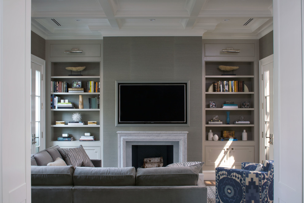 Cette image montre une salle de séjour traditionnelle avec un mur gris, un sol en bois brun, une cheminée standard, un téléviseur fixé au mur et un sol marron.