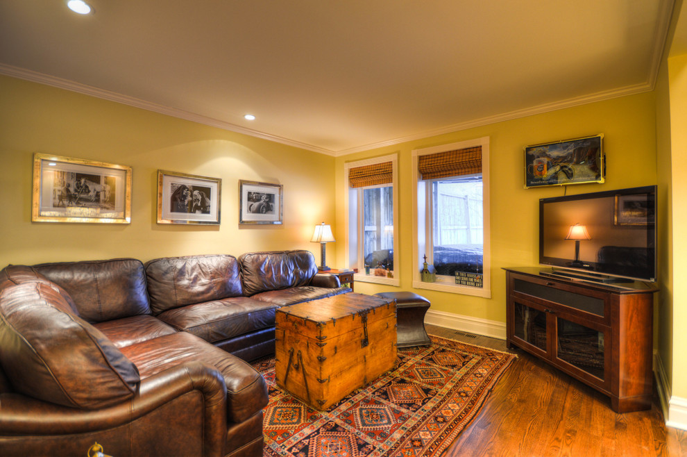 Свежая идея для дизайна: изолированная гостиная комната среднего размера в классическом стиле с желтыми стенами, паркетным полом среднего тона и телевизором в углу без камина - отличное фото интерьера