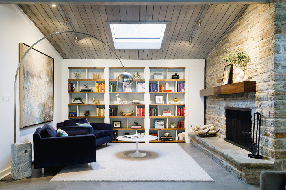 ボルチモアにある高級な中くらいなトランジショナルスタイルのおしゃれなオープンリビング (白い壁、スレートの床、標準型暖炉、石材の暖炉まわり、テレビなし、グレーの床) の写真