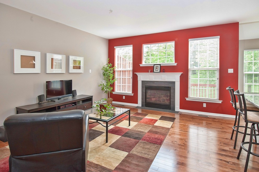Источник вдохновения для домашнего уюта: открытая гостиная комната среднего размера в современном стиле с стандартным камином, фасадом камина из плитки, красными стенами, паркетным полом среднего тона и отдельно стоящим телевизором