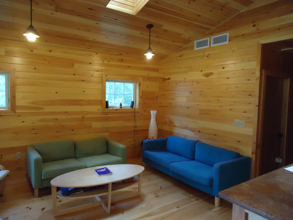 Ejemplo de sala de estar abierta rústica pequeña sin televisor con paredes amarillas y suelo de madera clara