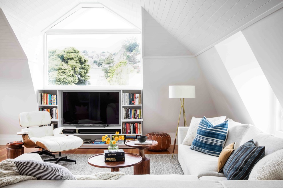 Diseño de sala de estar con biblioteca clásica renovada de tamaño medio con paredes blancas, pared multimedia, suelo de madera en tonos medios y alfombra
