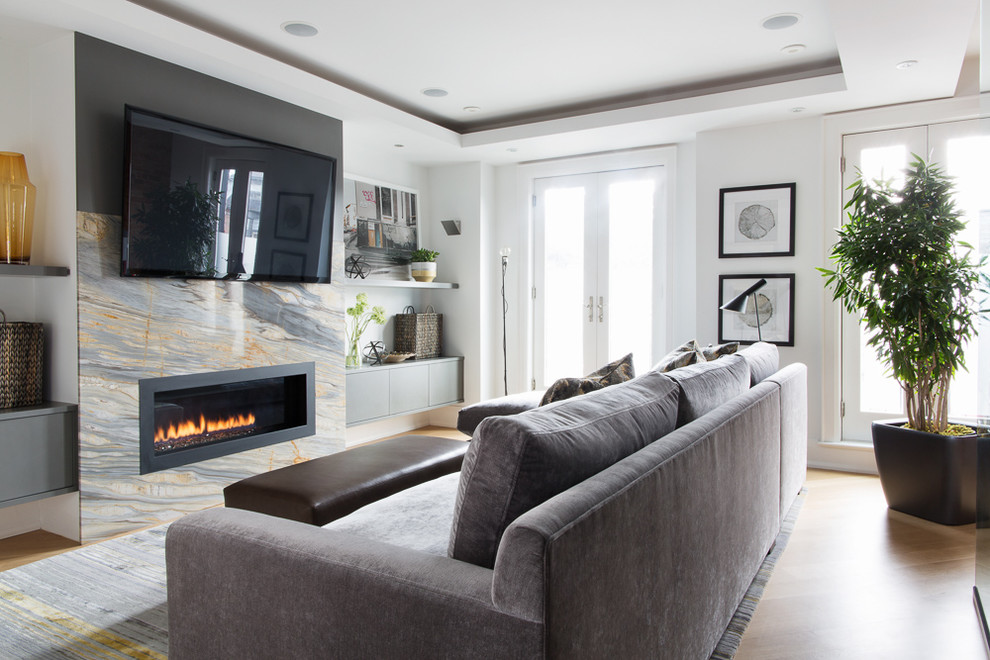 Design ideas for a small contemporary open plan games room in Toronto with white walls, light hardwood flooring, a ribbon fireplace, a stone fireplace surround, a wall mounted tv and beige floors.