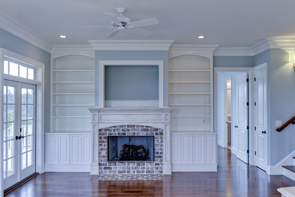 Elegant medium tone wood floor and brown floor family room photo in Charleston with blue walls