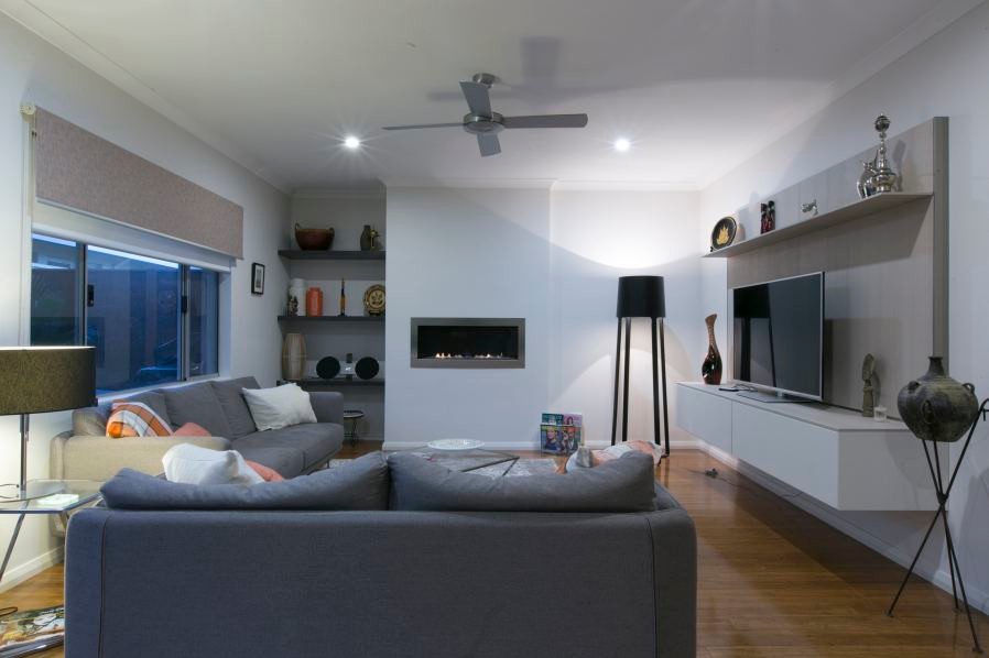 Aménagement d'une salle de séjour moderne de taille moyenne avec un mur blanc, parquet en bambou et un téléviseur encastré.