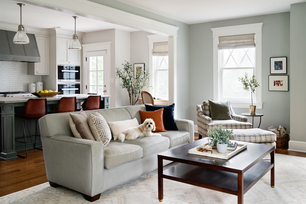 Imagen de sala de estar abierta tradicional renovada grande con paredes verdes, suelo de madera en tonos medios, todas las chimeneas y televisor colgado en la pared