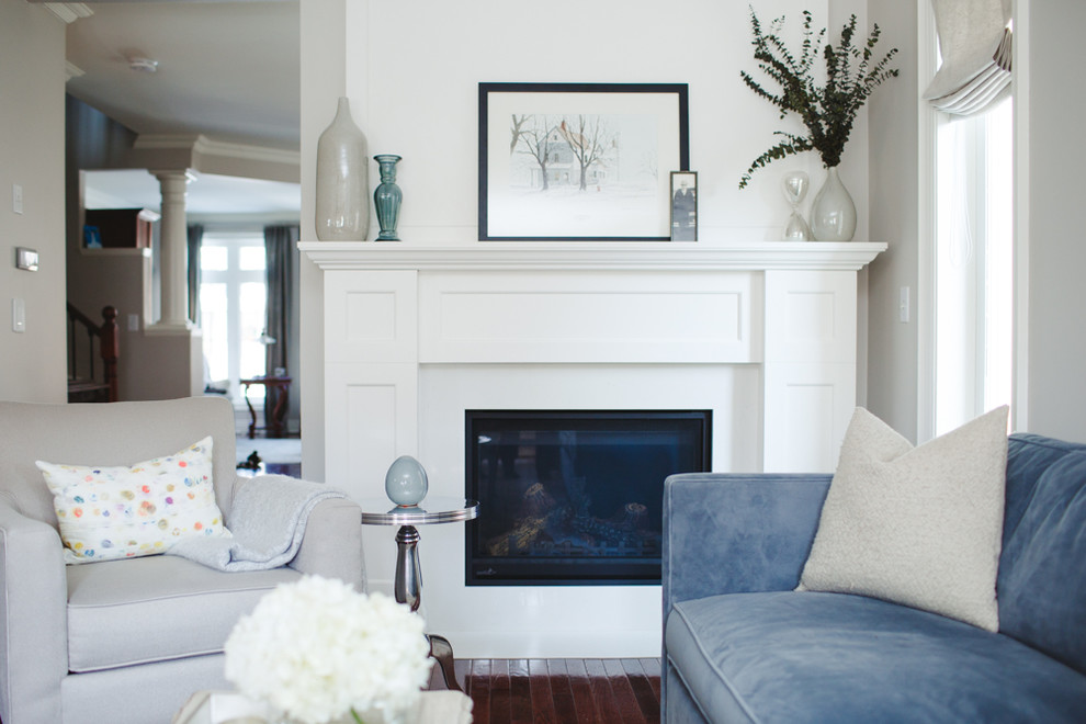 Kleines, Fernseherloses, Abgetrenntes Klassisches Wohnzimmer mit grauer Wandfarbe, braunem Holzboden, Kamin, Kaminumrandung aus Stein und braunem Boden in Toronto
