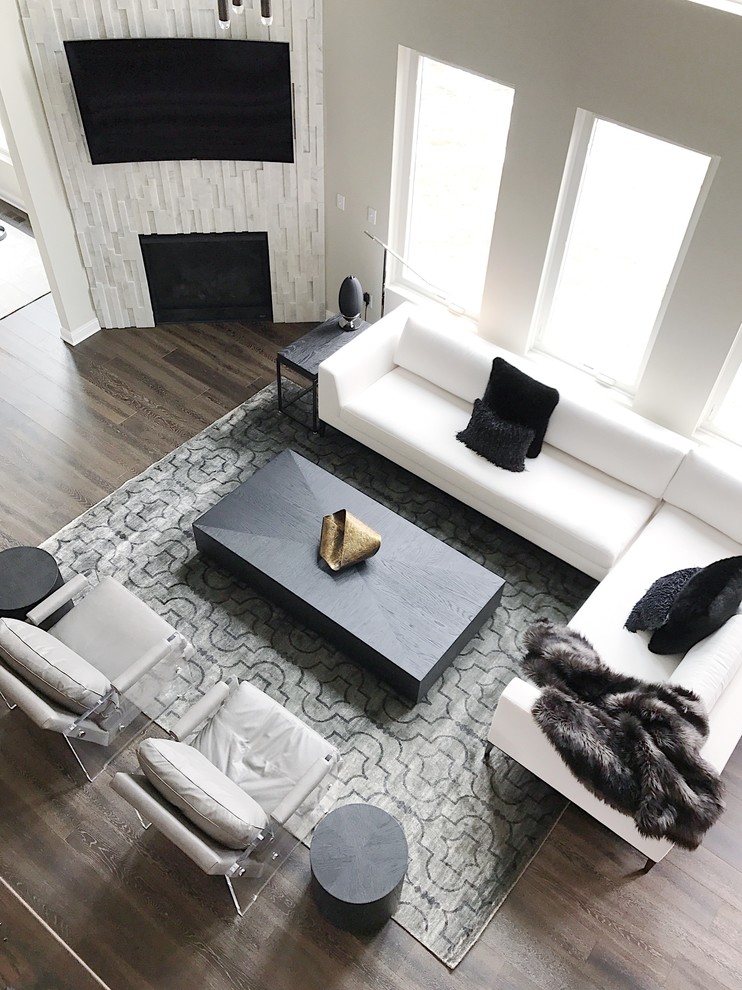 Großes, Offenes Modernes Wohnzimmer mit grauer Wandfarbe, dunklem Holzboden, Eckkamin, gefliester Kaminumrandung, TV-Wand und braunem Boden in Detroit