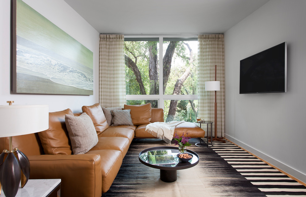 Modelo de sala de estar actual pequeña con paredes grises y televisor colgado en la pared