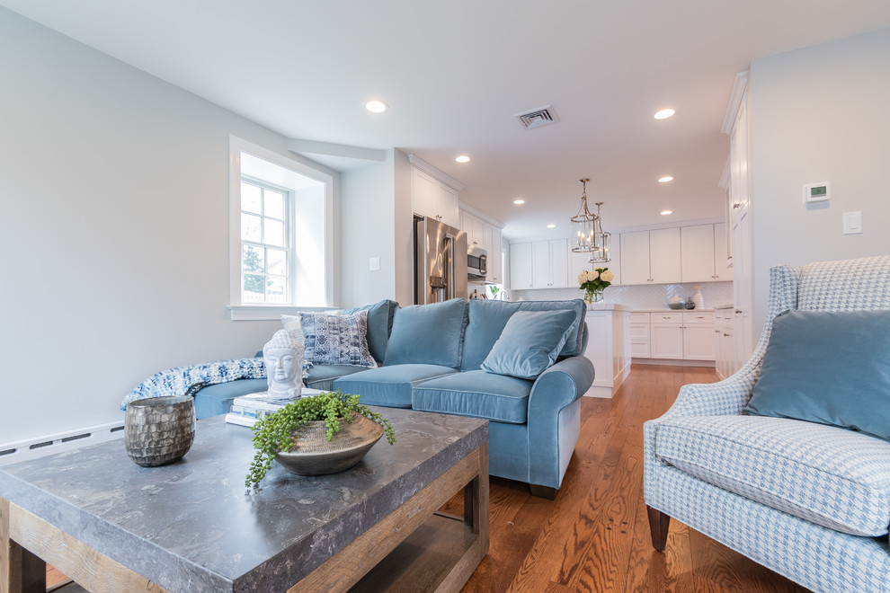 Esempio di un soggiorno design di medie dimensioni e aperto con pareti blu, pavimento in legno massello medio, nessun camino, TV a parete e pavimento marrone