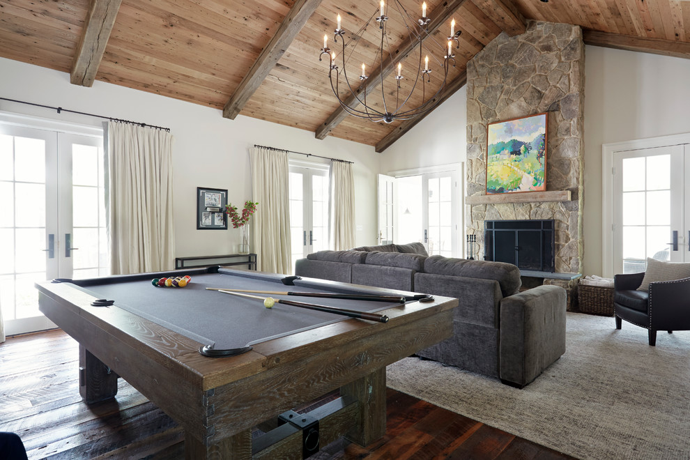 Farmhouse open plan games room in Richmond with white walls, a standard fireplace, a stone fireplace surround, dark hardwood flooring and brown floors.