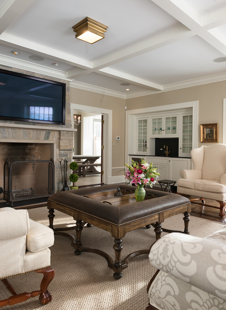 Family room - large traditional enclosed medium tone wood floor family room idea in Chicago with a bar, beige walls, a standard fireplace, a stone fireplace and a wall-mounted tv