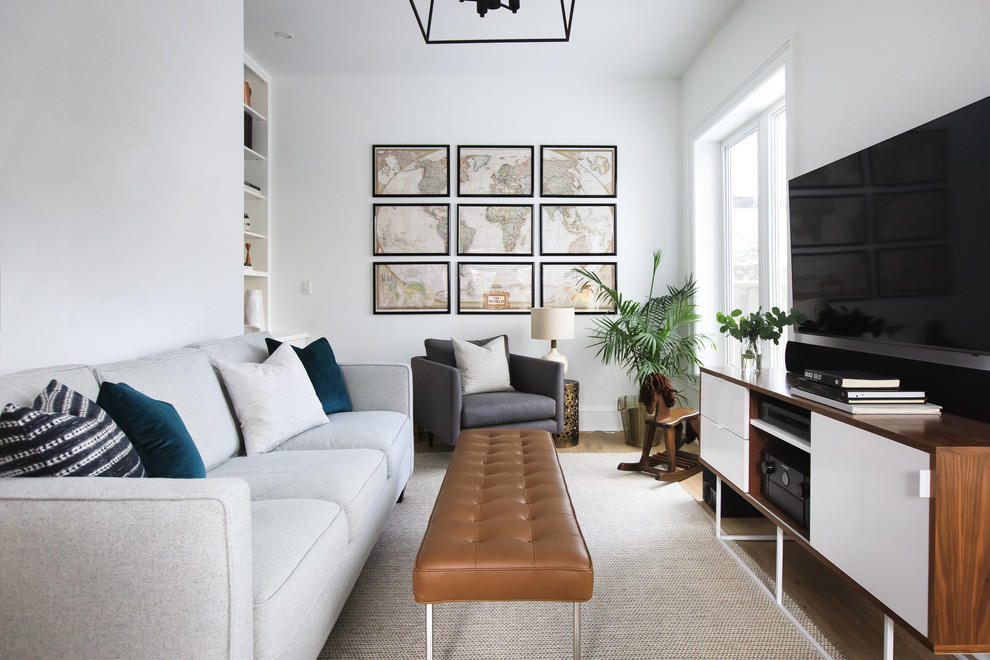Ejemplo de sala de estar abierta tradicional renovada pequeña sin chimenea con paredes blancas, suelo de madera clara, televisor colgado en la pared, suelo marrón y alfombra