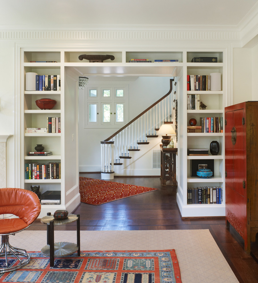 Ejemplo de sala de estar con biblioteca cerrada tradicional con paredes blancas y suelo de madera oscura