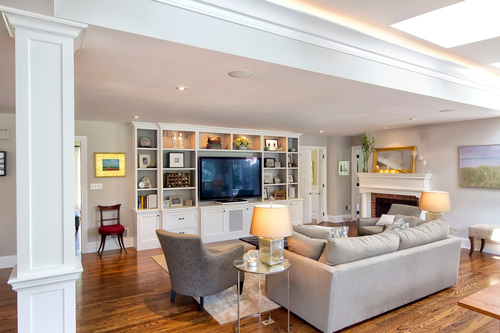 Offenes Klassisches Wohnzimmer mit grauer Wandfarbe, braunem Holzboden, Kamin und Kaminumrandung aus Holz in New York