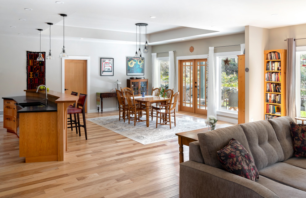 Imagen de sala de estar abierta de estilo americano con paredes beige, suelo de madera en tonos medios y bandeja
