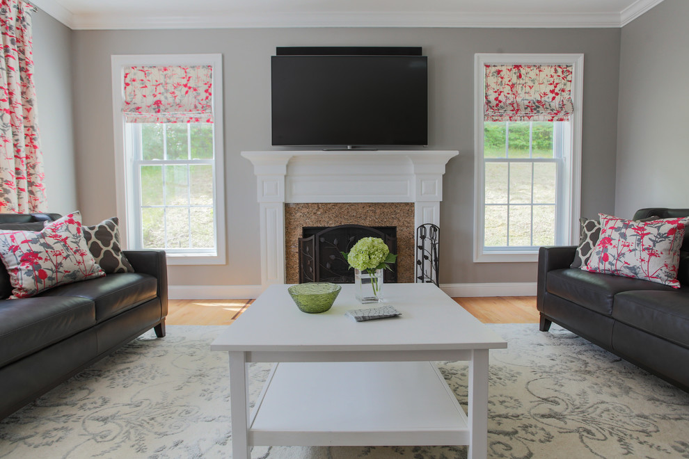 Ejemplo de sala de estar abierta contemporánea grande con paredes grises, suelo de madera clara, todas las chimeneas, marco de chimenea de piedra y televisor colgado en la pared