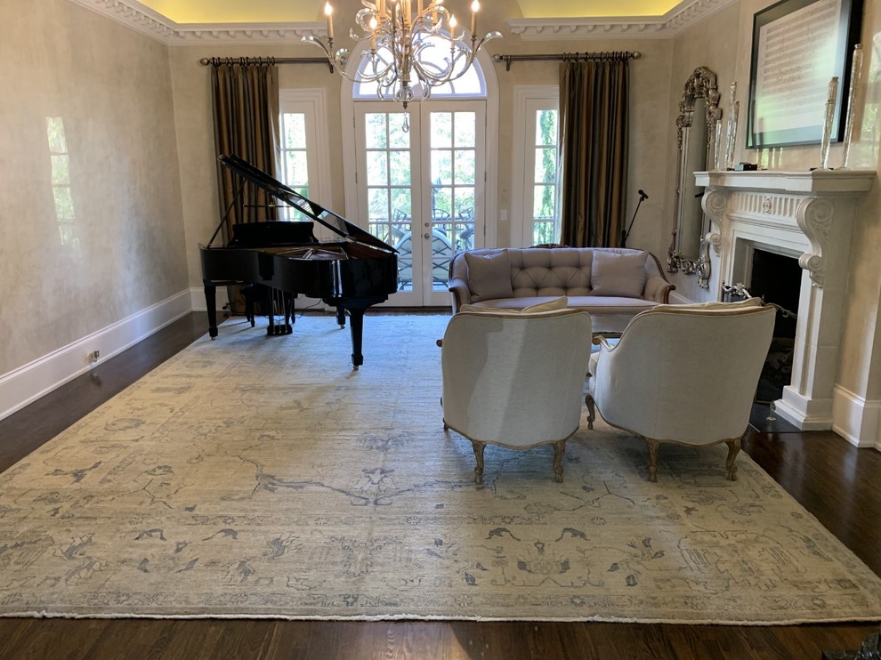 Diseño de sala de estar con rincón musical clásica renovada grande con paredes beige, suelo de madera oscura, estufa de leña, marco de chimenea de piedra y suelo marrón