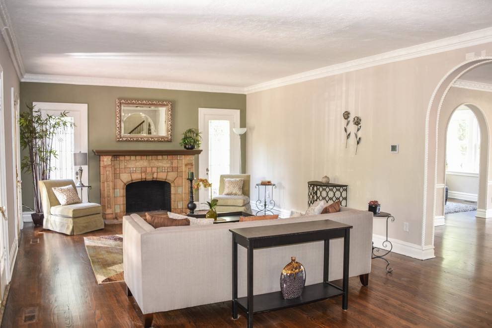 Klassisches Wohnzimmer mit grüner Wandfarbe, braunem Holzboden, Kamin und Kaminumrandung aus Stein in St. Louis