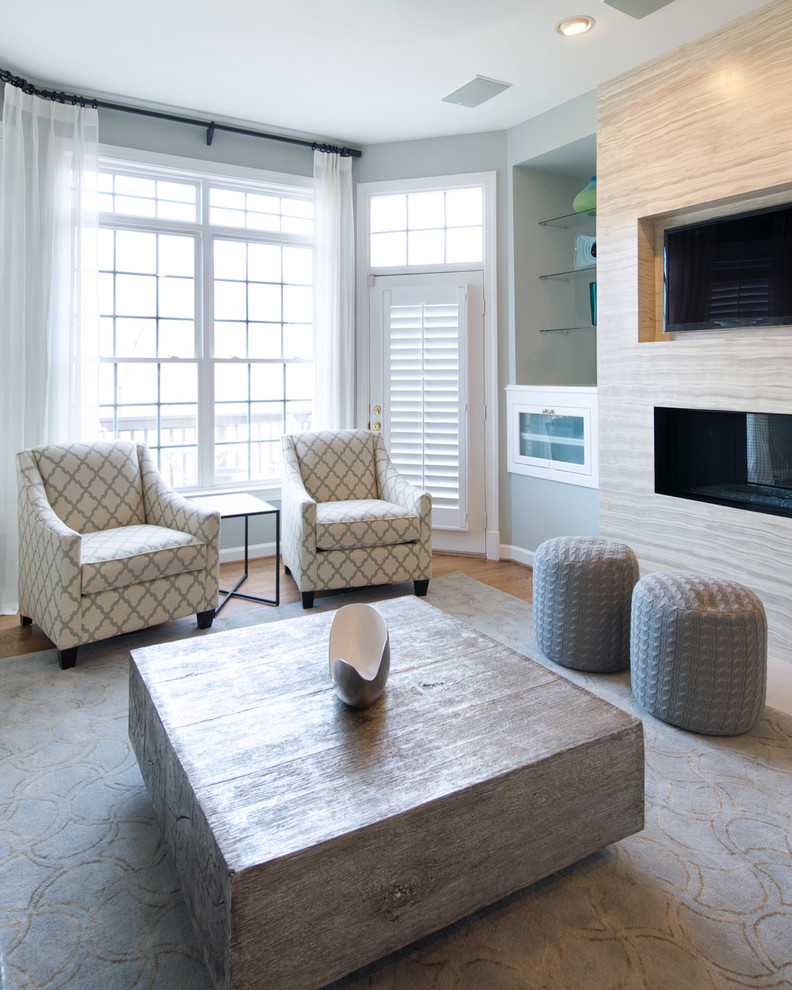 Esempio di un soggiorno contemporaneo di medie dimensioni con pareti blu, pavimento in legno massello medio, camino bifacciale, cornice del camino in metallo, TV a parete e pavimento marrone