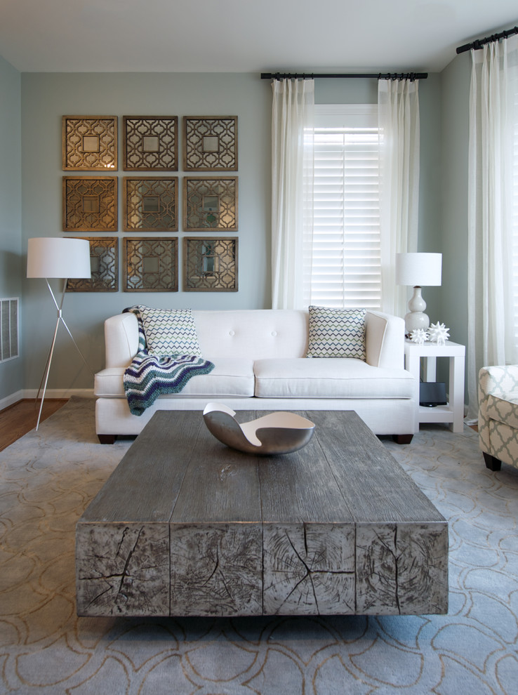 Imagen de sala de estar contemporánea de tamaño medio con suelo de madera en tonos medios, televisor colgado en la pared, paredes grises y suelo marrón