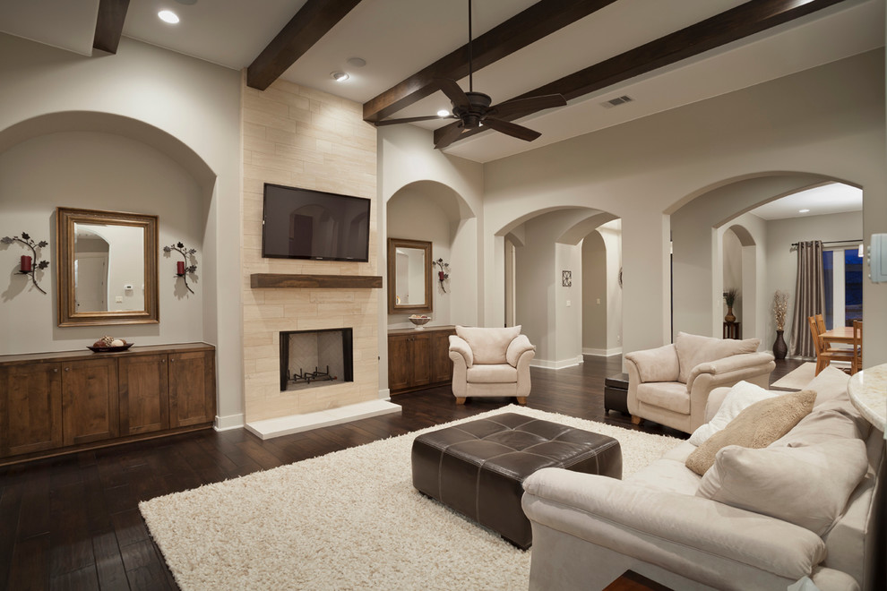 Family room - modern dark wood floor family room idea in Austin with beige walls, a stone fireplace and a wall-mounted tv