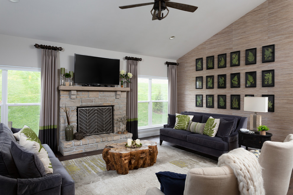 Cette image montre une salle de séjour traditionnelle de taille moyenne avec un mur beige, parquet foncé, une cheminée standard, un manteau de cheminée en pierre et un sol marron.