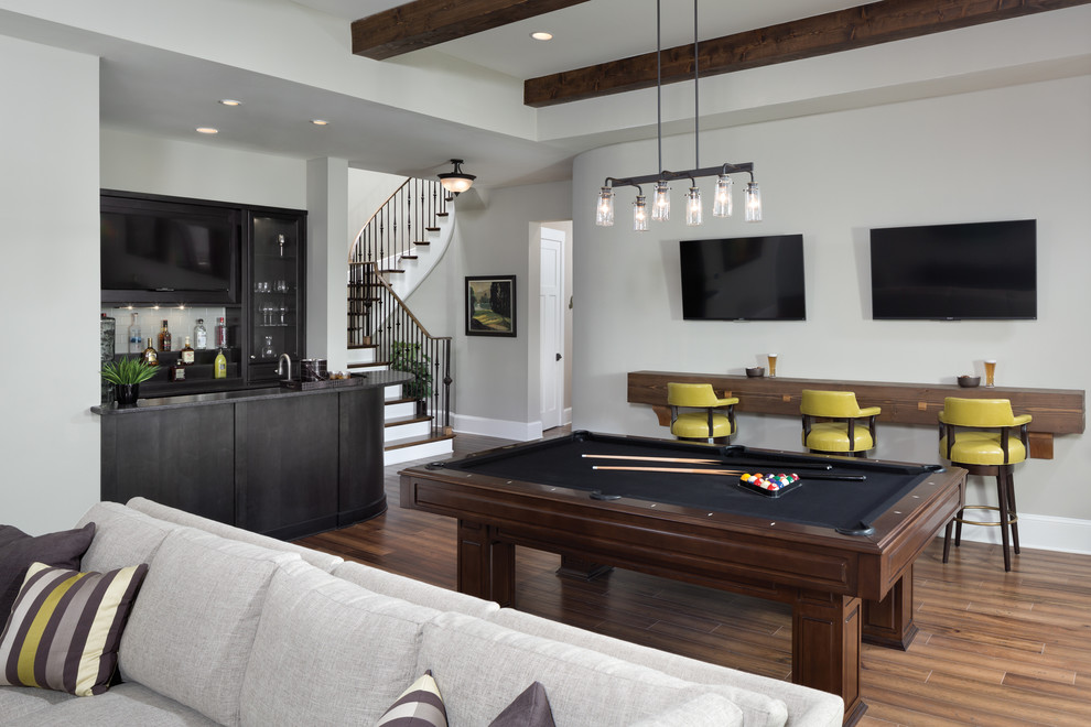 This is an example of a classic open plan games room in Other with grey walls, medium hardwood flooring and a wall mounted tv.