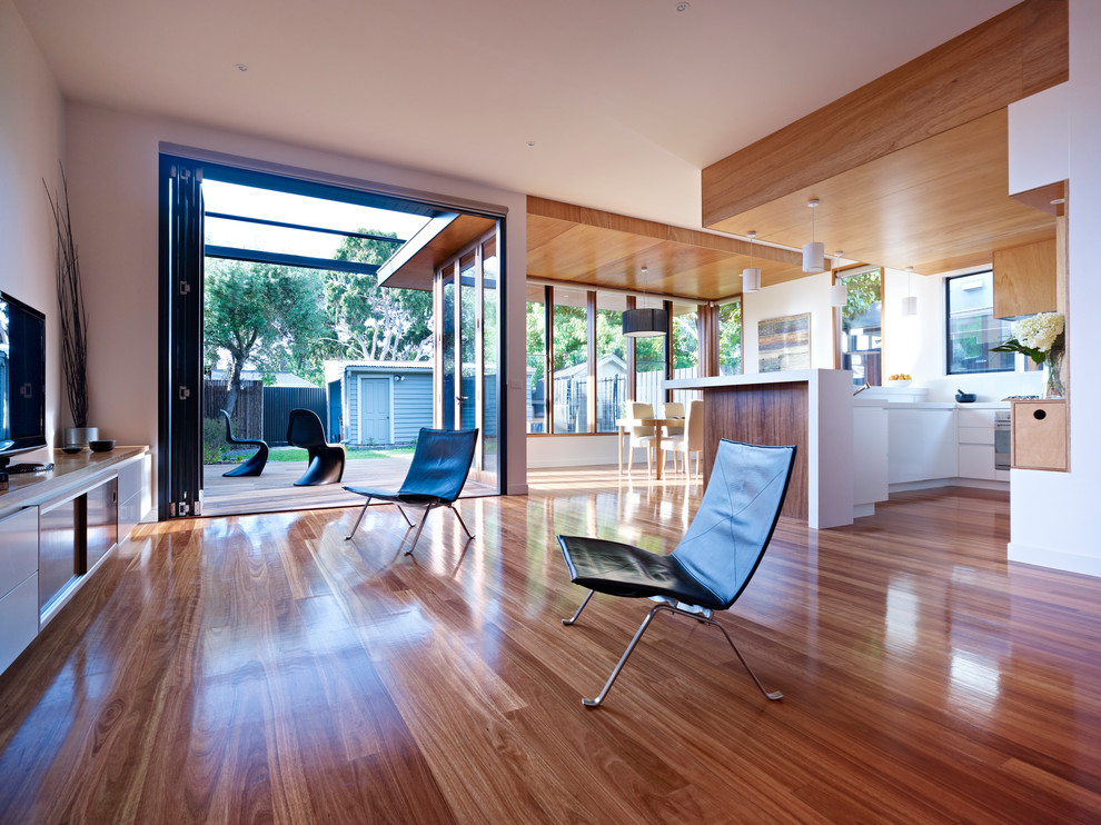 Mittelgroßes, Offenes Modernes Wohnzimmer mit weißer Wandfarbe, hellem Holzboden und freistehendem TV in Melbourne