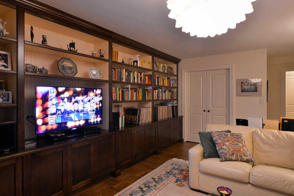 Idée de décoration pour une grande salle de séjour tradition ouverte avec une bibliothèque ou un coin lecture, un mur beige, un sol en bois brun et un téléviseur indépendant.