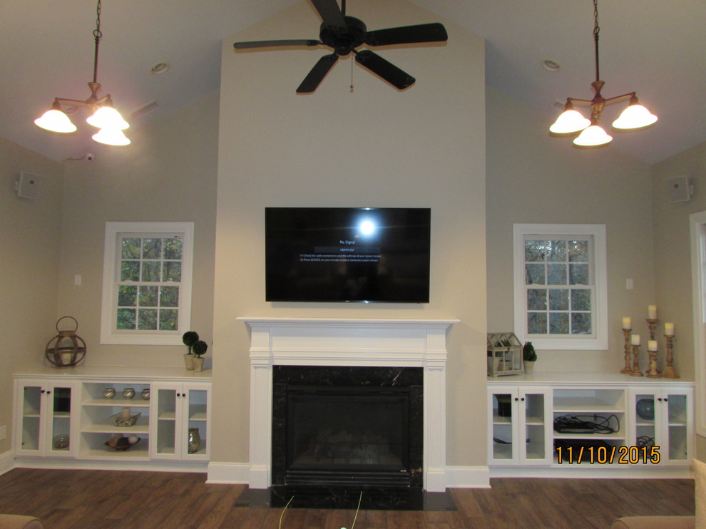 Imagen de sala de estar abierta tradicional extra grande con suelo de baldosas de porcelana, todas las chimeneas y televisor colgado en la pared