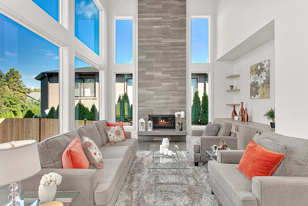 Großes, Offenes Modernes Wohnzimmer mit weißer Wandfarbe, braunem Holzboden, Hängekamin, Kaminumrandung aus Stein, TV-Wand und grauem Boden in Seattle