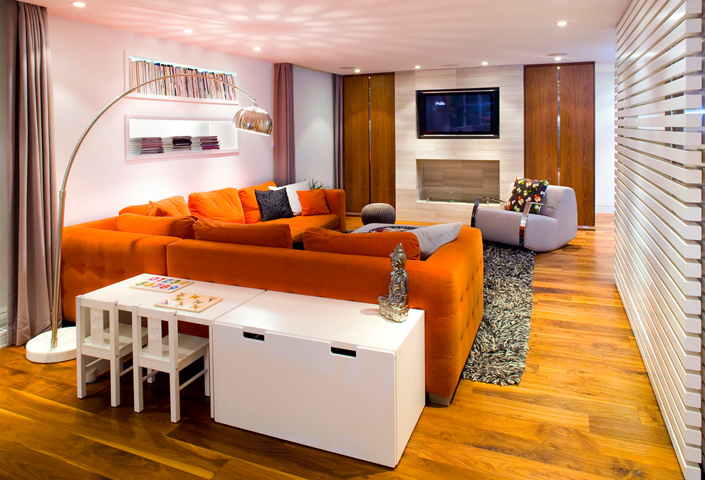 Großes, Offenes Modernes Wohnzimmer mit weißer Wandfarbe, braunem Holzboden, TV-Wand und Kaminumrandung aus Stein in Vancouver